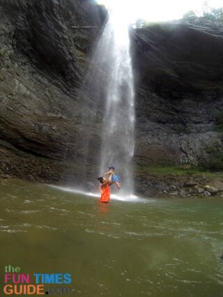 Playing underneath the waterfall at Ozone Falls while standing in the swimming hole.