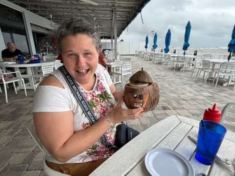 My wife holds her pina colada in keepsake coconut on our first visit there during the forming nor'easter near Daytona Beach. 