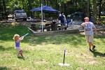 Sophie swinging the bat in a summer game of T-ball with Dad.