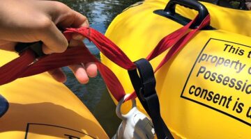 A closeup of our water bottle clipped onto the tether, and dangling in the water to keep it cool.
