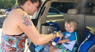 Applying sunscreen at the car before starting our float down the river with River Rat Tubing.