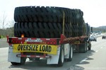 Wide load... a semi tractor-trailer carrying a load of extra-wide truck tires.
