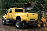 A bright yellow supertruck that doubles as a dump truck... it's an International CXT truck.